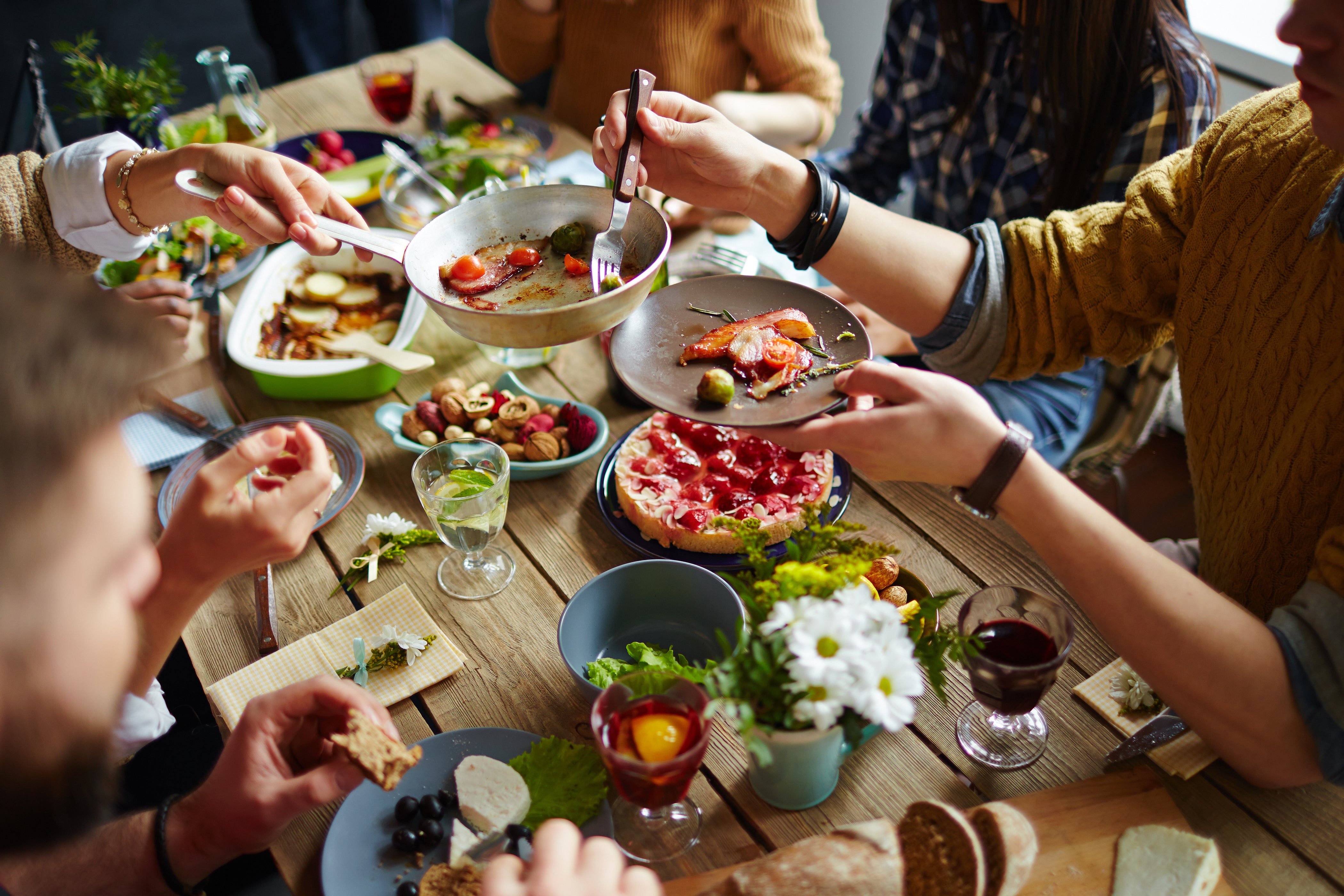 image of a group of friends sharing a family style meal from a cookbook club party